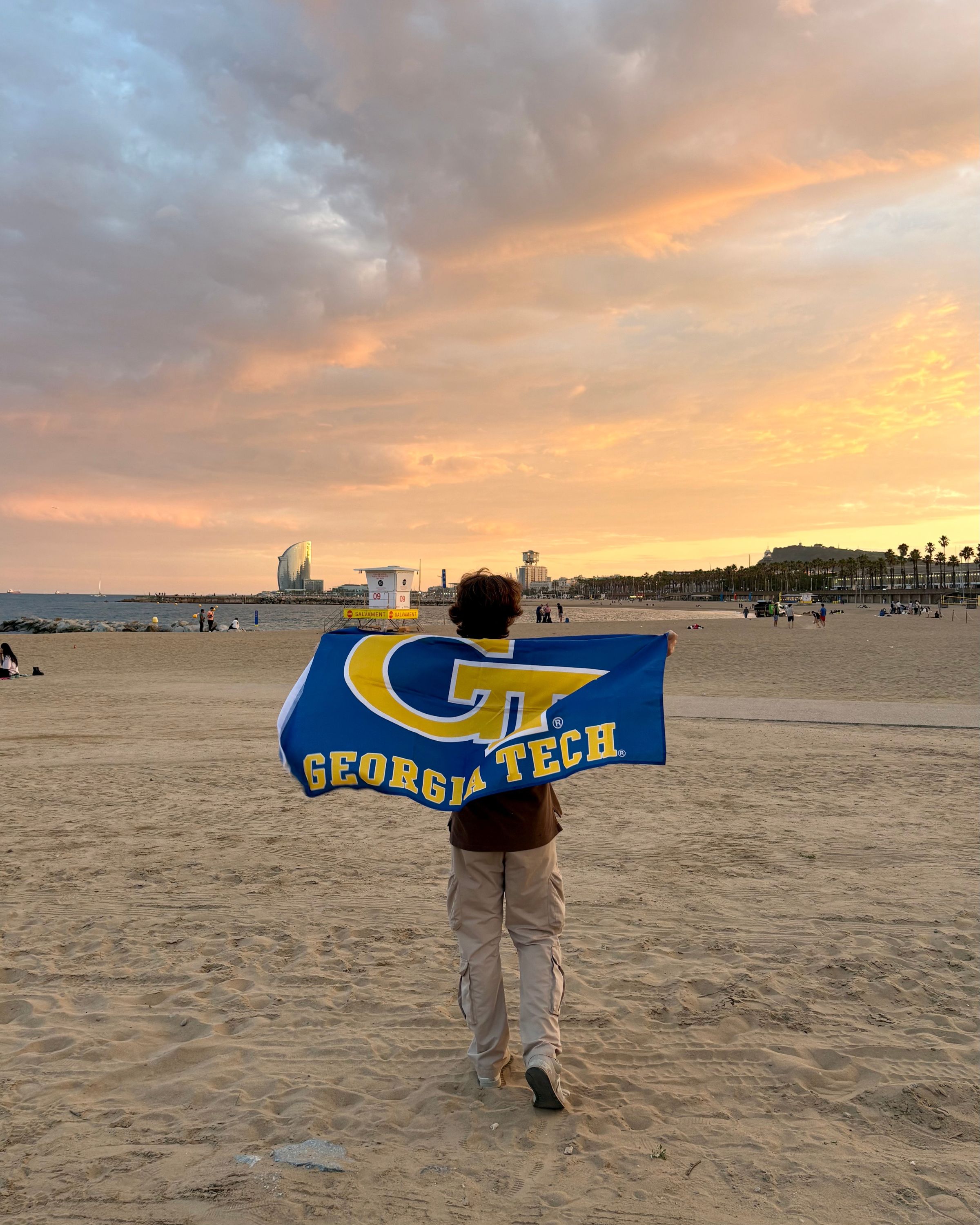 GT student on beach with GT flag